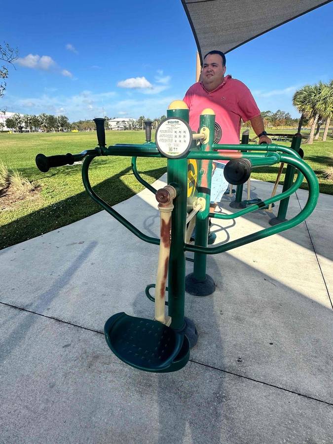 A participant using outdoor exercise equipment at a park