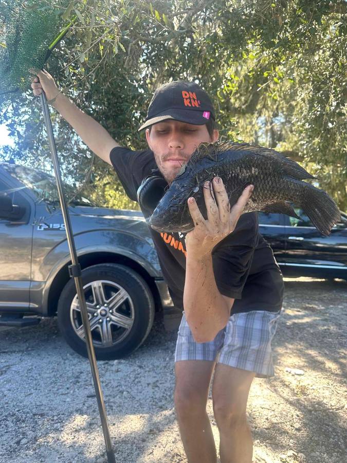 A participant proudly holding up a fish he caught