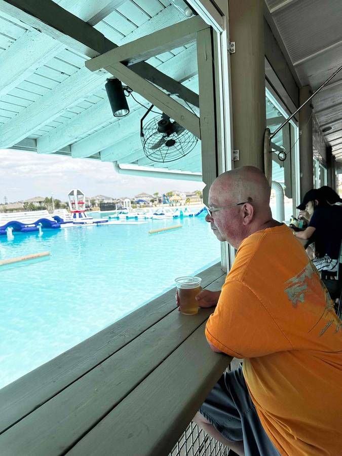 A man looking out over a water park